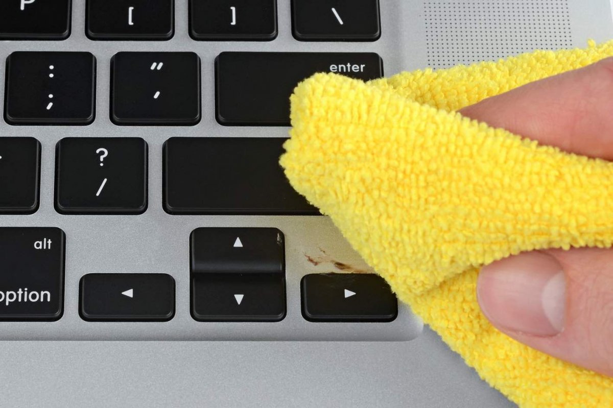 Cleaning a laptop keyboard with a microfiber cloth