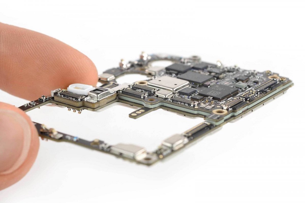 Finger holding the motherboard of a Huawei P30 Pro