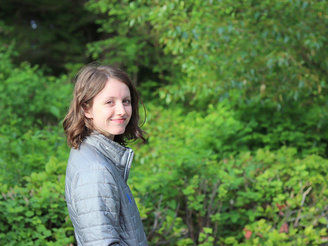 Olivia smiling in a forest