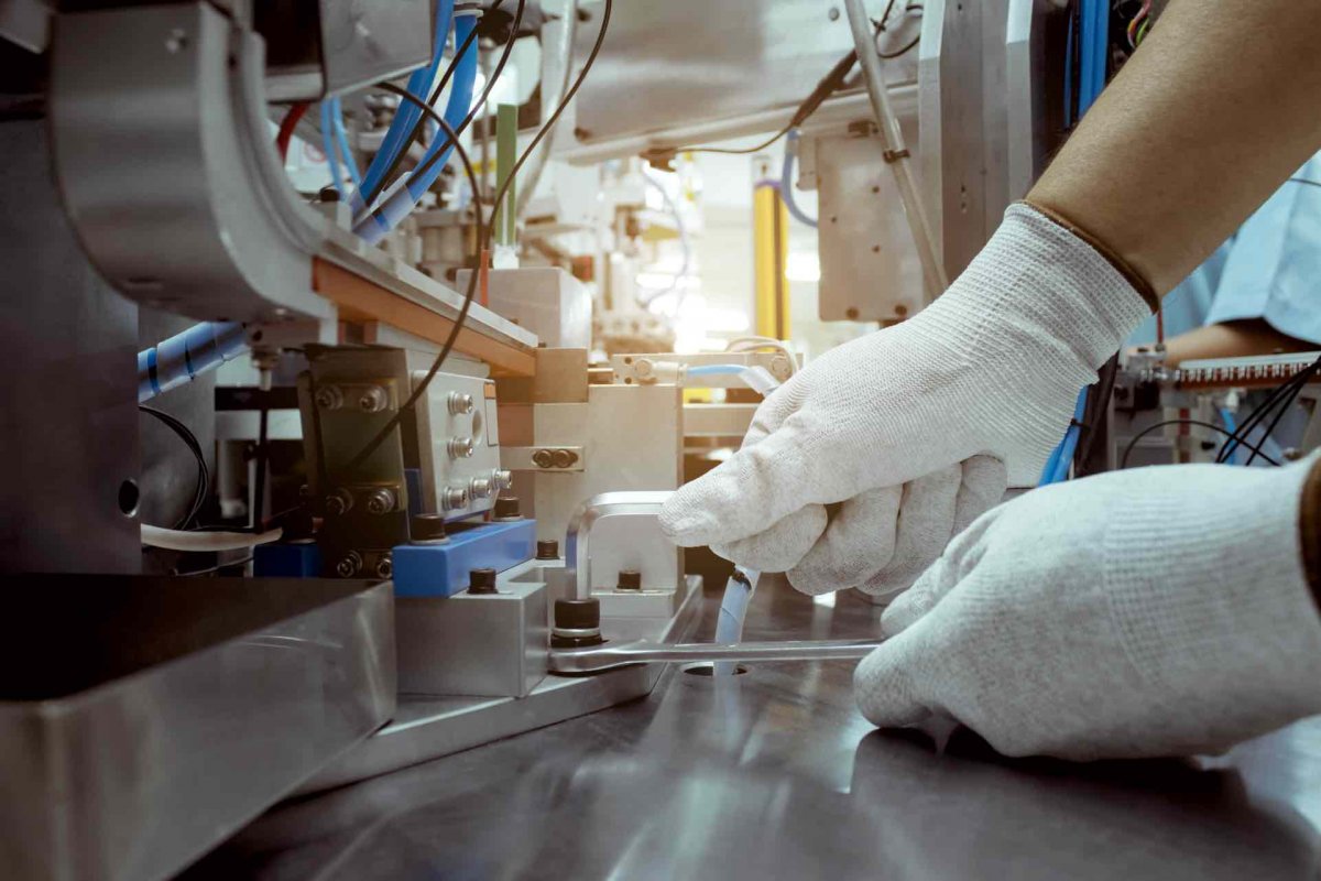 Gloved hands repairing a medical device