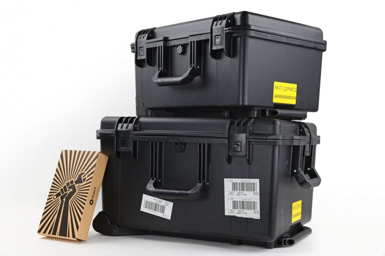 A stack of pelican cases full of Apple tools with an iFixit toolkit leaning against it