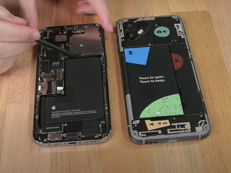 An iPhone (left) side-by-side with a Fairphone 4 (right). Both have rear panels removed to display their batteries.