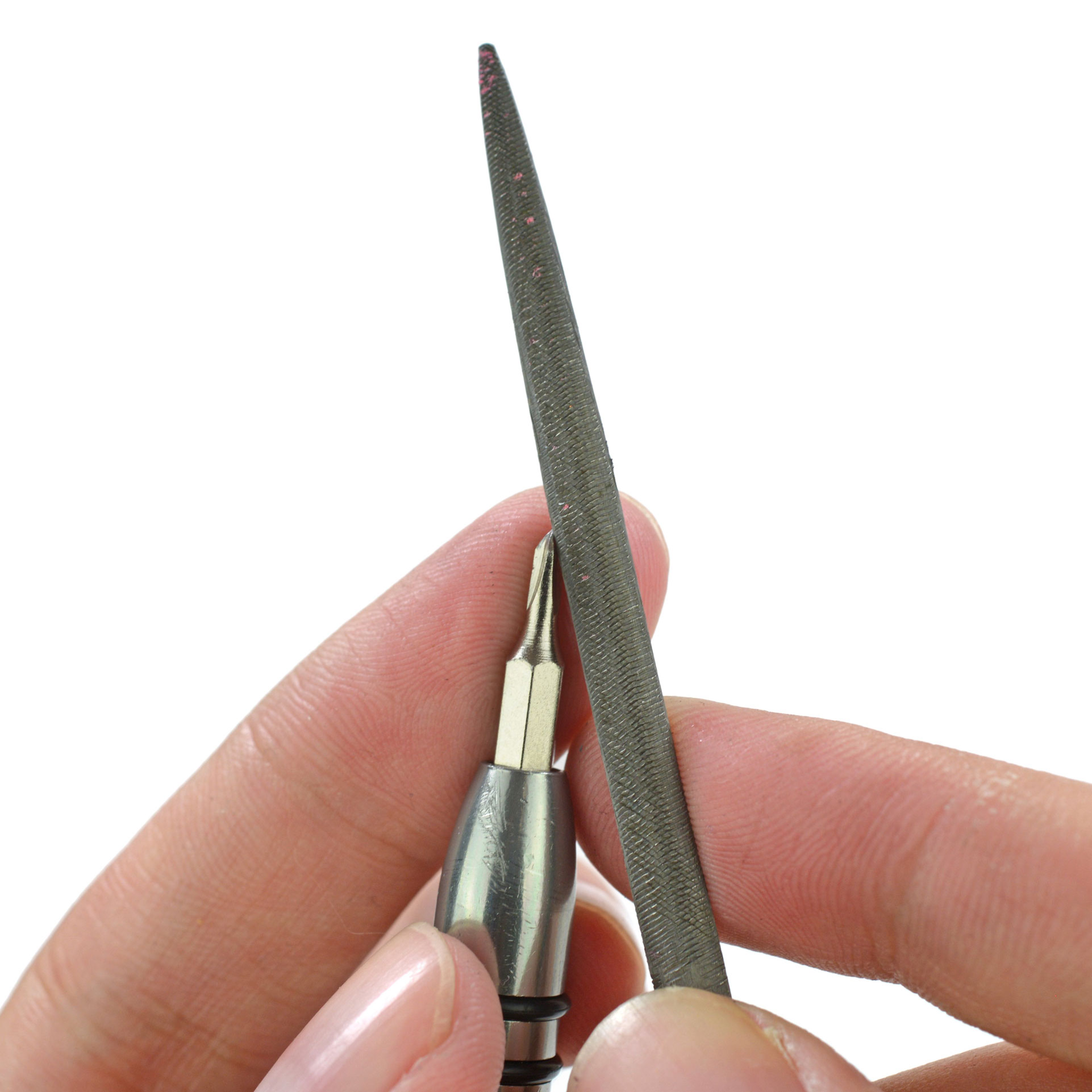 Filing the tip of a screwdriver bit with a jeweler's file to fit into a tiny screw.