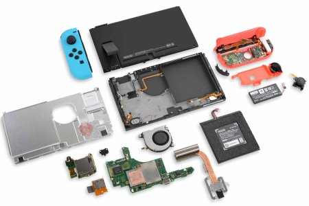 A Nintendo Switch, disassembled with its components laid out neatly on the teardown table.